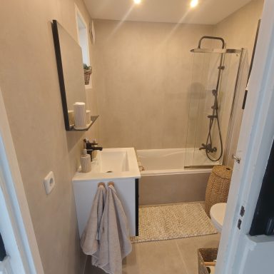 Klein moderne badkamer met douche en bad, lichte muren en minimalistische inrichting.
